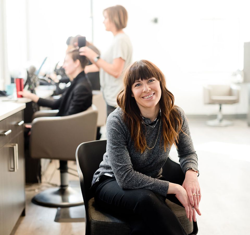 female business owner sits in her salon